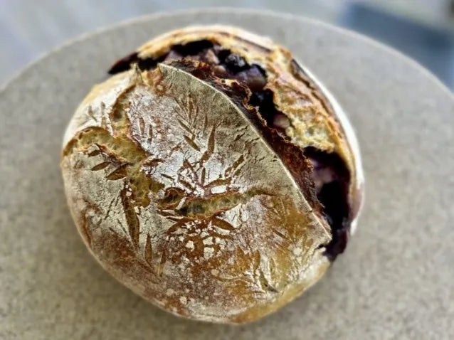 Rustic loaf of berry cream cheese sourdough bread on a tan plate. Baked in the kitchen at Nystrom Orchard in Worthington Minnesota.