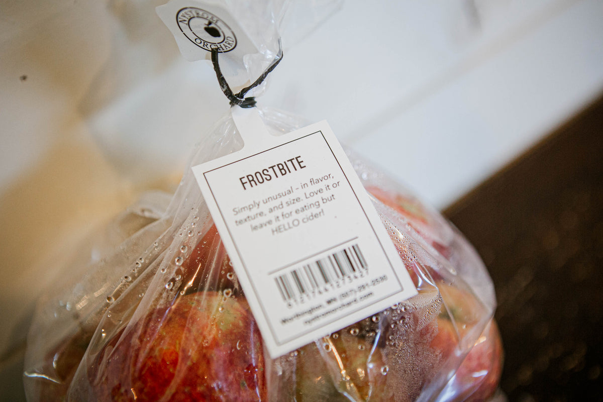 Label for frostbite apples with apples in a bag with a white background. Picked in Nystrom Orchard in Worthington Minnesota.
