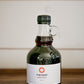 16 oz jug of maple syrup on a wooden table on a white background. Sold by Nystrom Orchard in Worthington Minnesota.