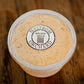 Container of maple bacon cheese dip with a lid on a wooden surface.  Made in the kitchen of Nystrom Orchard in Worthington Minnesota.