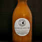 Large bottle of cold pressed cider on a dark background. Pressed in the kitchen of Nystrom Orchard in Worthington Minnesota.