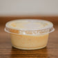 2 oz container with a lid of house made honey mustard on a wooden surface. Made in the kitchen of Nystrom Orchard in Worthington Minnesota.