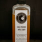 Bottle of cold pressed apple cider with a label on a dark background. Made in the kitchen at Nystrom Orchard in Worthington Minnesota.