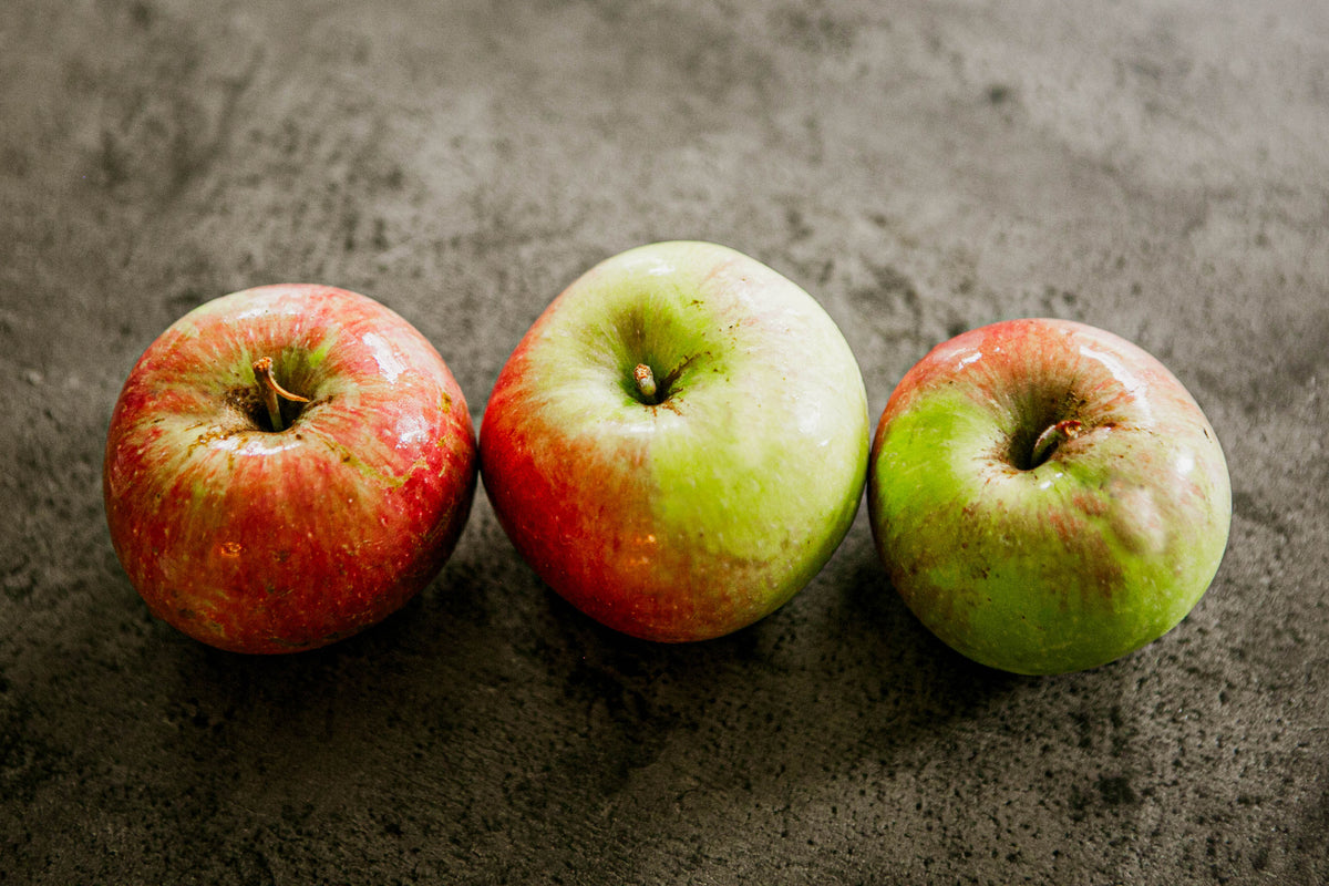 3 Wealthy apples in a row on a concrete surface. Picked in Nystrom Orchard in Worthington Minnesota.