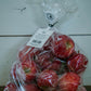Clear plastic bag of gala apples on a concrete surface with a white background. Picked at Nystrom Orchard in Worthington Minnesota.