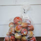 A clear plastic bag of apples of the variety frostbite on a wooden table with a white background. Picked in the orchard of Nystrom Orchard in Worthington Minnesota.