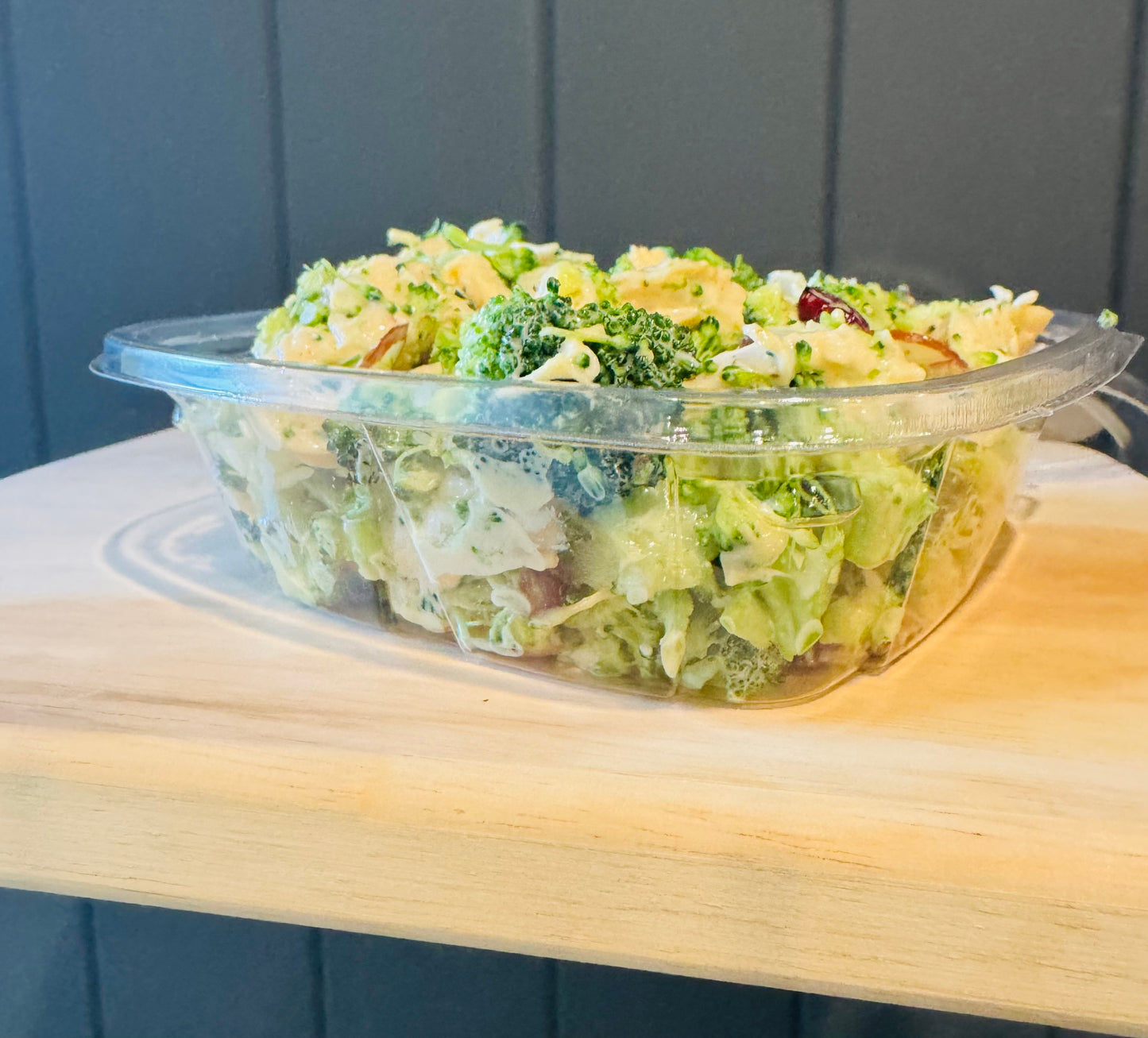 8 oz clear plastic container of broccoli salad with chicken. Made in the kitchen of Nystrom Orchard in Worthington Minnesota.