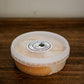 Apple pie dip in a clear plastic container topped with caramel on a wooden surface. Made in the kitchen of Nystrom Orchard in Worthington Minnesota.