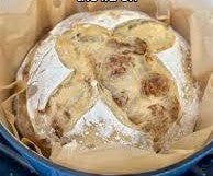 Loaf of rustic sourdough bread in a blue dutch oven. Baked in the kitchen of Nystrom Orchard in Worthington Minnesota. 