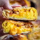 Soft pretzel wrap cut in half to show that its full of eggs, cheese and bacon with a blurry background. Made in the kitchen of Nystrom Orchard in Worthington Minnesota.