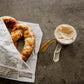 Baked Soft Pretzel in newspaper wrapping with apple pie dip on a dark surface. Made in the kitchen of Nystrom Orchard in Worthington Minnesota.