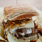 Close-up of a beef slider on a bun with garlic aioli, provolone, and crispy onions. Made in the kitchen at Nystrom Orchard in Worthington Minnesota.
