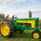 Boy and his grandpa on an old tractor beside a field with an apple tree in the background. Event hosted by Nystrom Orchard in Worthington Minnesota.