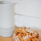 Loaf of artisan sourdough bread with pepperoni and cheese on a wooden table with a white pitcher in the background. Baked in the kitchen at Nystrom Orchard in Worthington Minnesota.