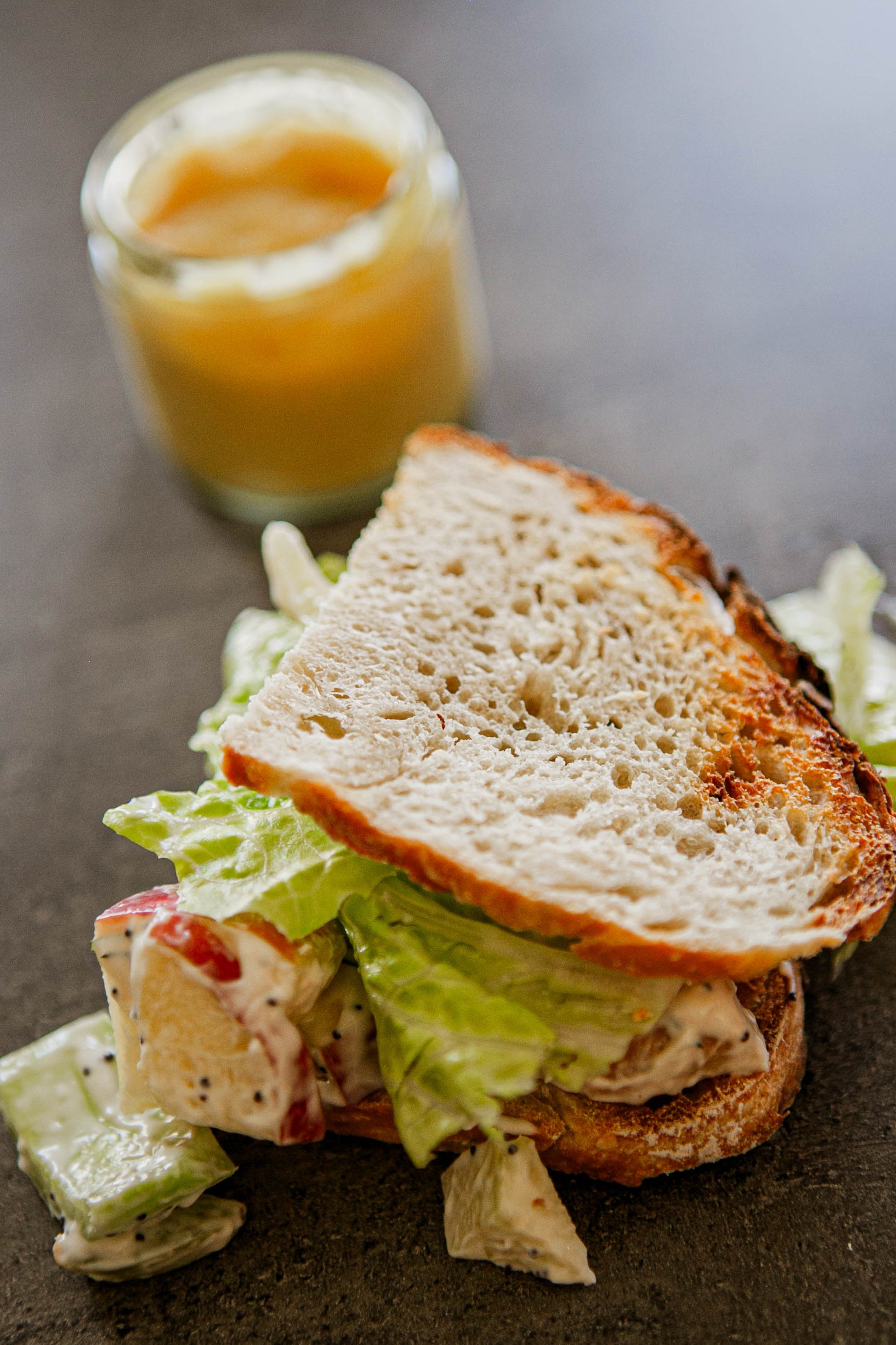 Sourdough Sandwich with chicken salad and lettuce with a honey mustard dipping sauce in the background. Made in the kitchen of Nystrom Orchard in Worthington Minnesota.