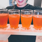 Person holding a wooden board with cold pressed cider flight. Pressed at Nystrom Orchard in Worthington Minnesota.