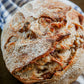 Fresh artisan cinnamon sugar butter sourdough loaf on a white and blue towel on a dark surface. Baked in the kitchen in of Nystrom Orchard in Worthington Minnesota.