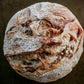 Loaf of bread with a rustic crust on a dark background. Baked in the kitchen of Nystrom Orchard in Worthington Minnesota.