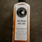 Bottle of Nystrom Orchard cold pressed cider on a black textured surface. Pressed in the kitchen at Nystrom Orchard in Worthington Minnesota. 