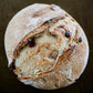 Rustic loaf of cranberry cream cheese sourdough bread loaf on a dark surface. Baked in the kitchen at Nystrom Orchard in Worthington Minnesota.