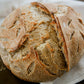 Loaf of sourdough bread with a rustic crust on a white cloth. Baked in the kitchen of Nystrom Orchard in Worthington Minnesota.