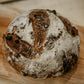 Mini loaf of double chocolate sourdough on a wooden cutting board.  Baked in the kitchen of Nystrom Orchard in Worthington Minnesota.