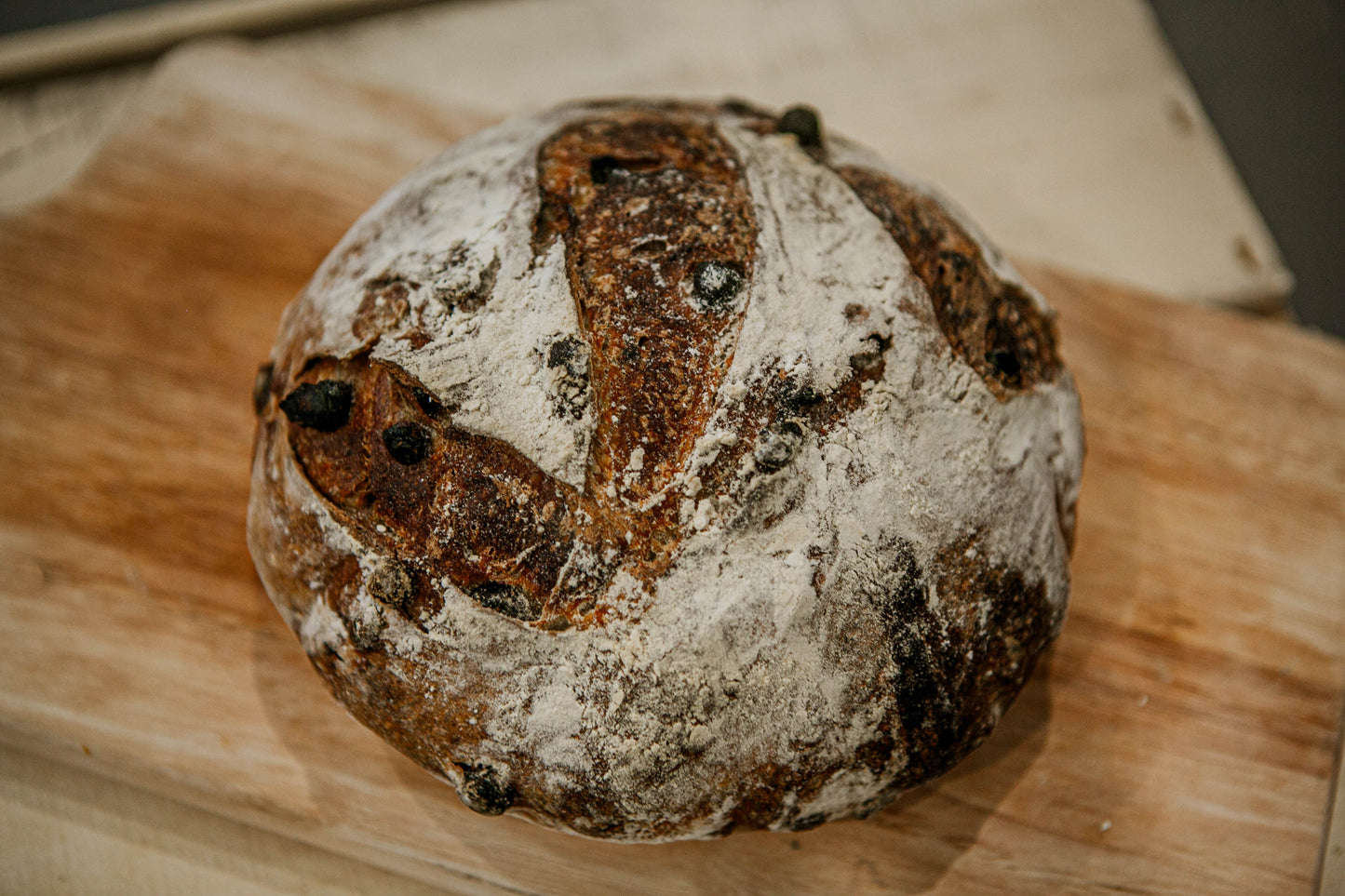 Mini loaf of double chocolate sourdough on a wooden cutting board.  Baked in the kitchen of Nystrom Orchard in Worthington Minnesota.