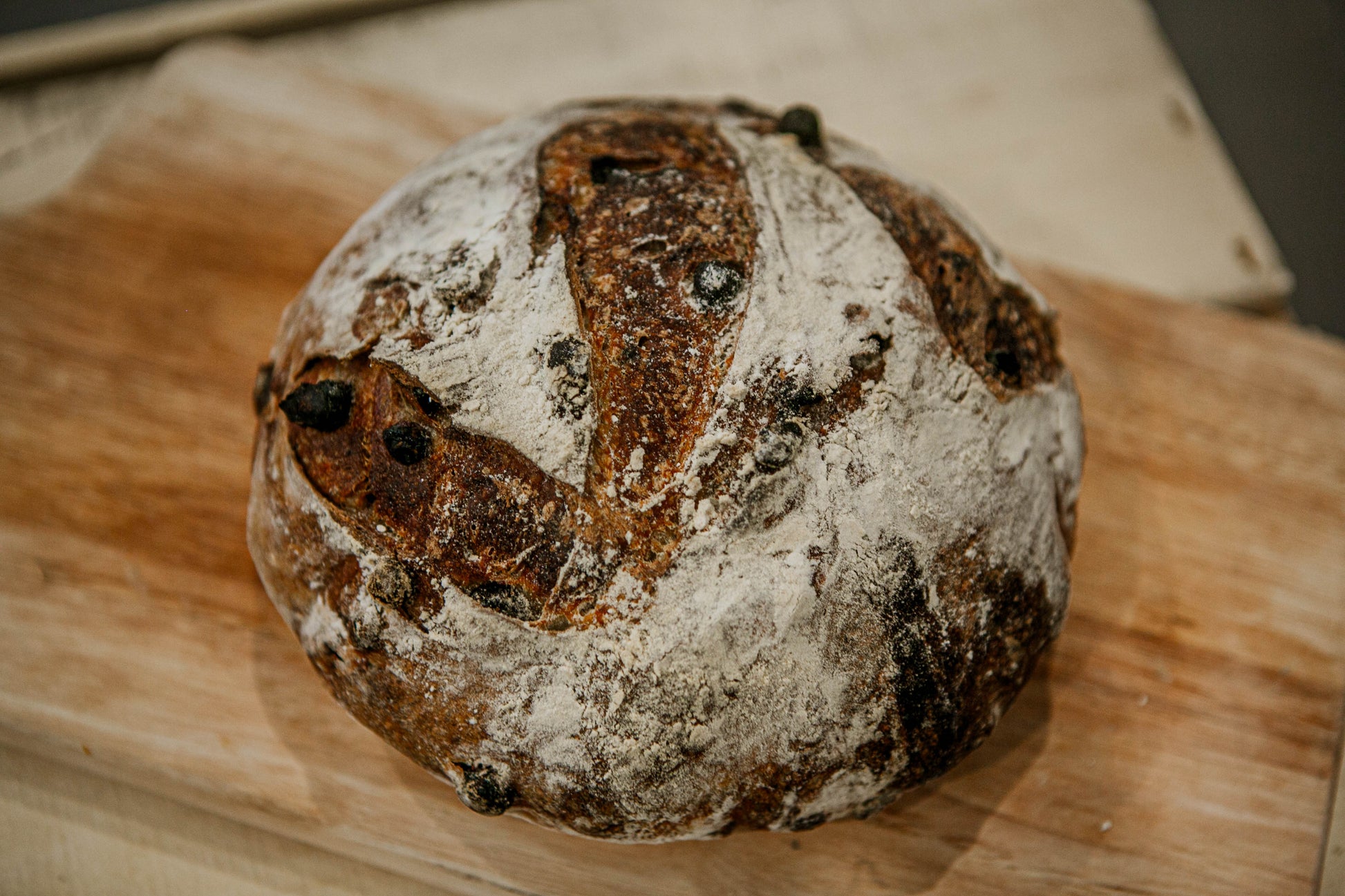 Mini loaf of double chocolate sourdough on a wooden cutting board.  Baked in the kitchen of Nystrom Orchard in Worthington Minnesota.