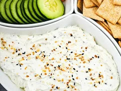 Dip with sour cream, cream cheese, and everything bagel seasoning, with cucumbers and crackers beside.  Made in the kitchen at Nystrom Orchard in Worthington Minnesota.