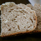 Two slices of herbed rustic sourdough bread on a dark surface. Baked in the kitchen of Nystrom Orchard in Worthington Minnesota.