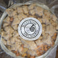 A foil pan with gluten free apple crisp frozen and pre-packaged on a wooden surface with a Nystrom Orchard label. Made in the kitchen of Nystrom Orchard in Worthington Minnesota.