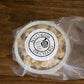 A packaged frozen mini pan of gluten free apple crisp on a wooden surface. Made in the kitchen of Nystrom Orchard in Worthington Minnesota.