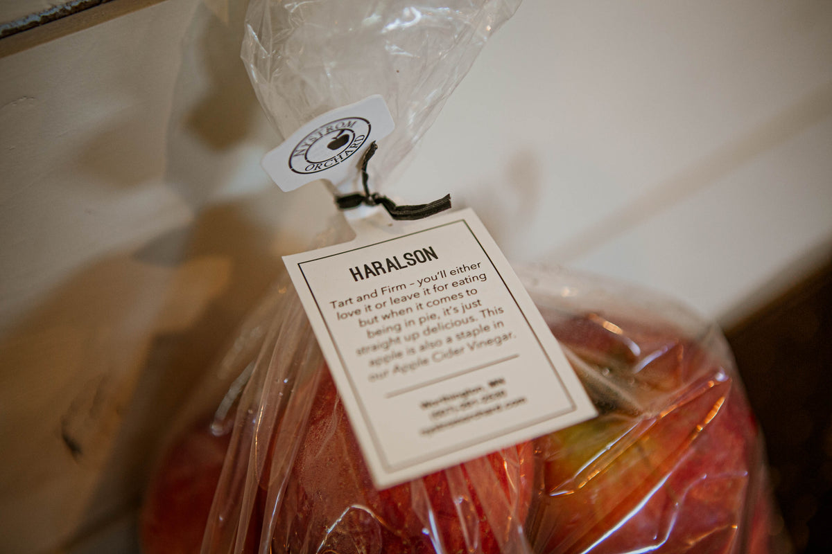 Apples in a plastic bag with a prominent tag that has branding as well. Picked in Nystrom Orchard in Worthington Minnesota. 