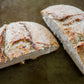 Two halves of roasted garlic cream cheese sourdough bread on a dark surface. Baked in the kitchen at Nystrom Orchard in Worthington Minnesota.