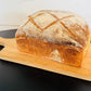 Loaf of sourdough sandwich bread on a wooden cutting board with a white background. Baked in the kitchen at Nystrom Orchard in Worthington Minnesota.