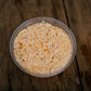 Container of maple bacon cheese dip on a wooden surface.  Made in the kitchen of Nystrom Orchard in Worthington Minnesota.