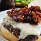 Close-up of a burger with cheese and maple bacon onion jam with a blurry background. Made in the kitchen of Nystrom Orchard in Worthington Minnesota.
