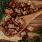 Wooden spoon filled with maple pecan snack mix on a wooden surface with Christmas decorations. Made in the kitchen at Nystrom Orchard in Worthington Minnesota.