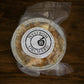 Mini apple crisp frozen and vacuum sealed in a foil pan on a wooden surface. Made in the kitchen of Nystrom Orchard in Worthington Minnesota.