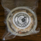 A frozen vacuum sealed package of gluten dairy free apple crisp on a wooden surface. Made in Nystrom Orchard in Worthington Minnesota.