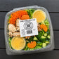 Plastic container of orange almond chicken salad with citrus dressing with visible branding on a wooden surface. Made fresh in the kitchen of Nystrom Orchard in Worthington Minnesota.