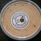 A plastic container of peanut butter cream cheese apple dip with a label that reads 'Nystrom Orchard' and has an image of an apple. Made in the kitchen of Nystrom Orchard in Worthington Minnesota.