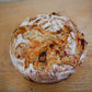 Rustic loaf of sourdough bread on a wooden cutting board. Baked in the kitchen of Nystrom Orchard in Worthington Minnesota. 