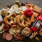 A picnic spread of soft pretzels misc. crackers, whoopie pies, dips, cheese, dried fruits, apples and drinks on a dark surface. Created in the kitchen of Nystrom Orchard in Worthington Minnesota.