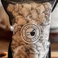 Bag of house made puppy chow a mixture of chex cereal chocolate, peanut butter and powdered sugar in a bag with a burry background. Mixed in the kitchen at Nystrom Orchard in Worthington Minnesota.