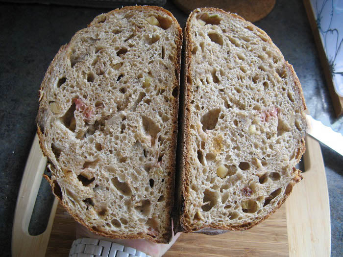 Sliced rustic loaf of rhubarb vanilla crumble sourdough bread cut in half on top of a cutting board. Baked in the kitchen at Nystrom Orchard in Worthington Minnesota.