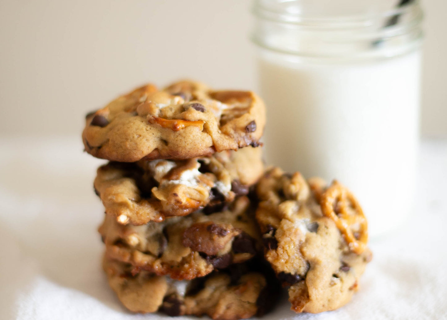 Stack of salted orchard smore cookies with a glass of milk on a white surface.  Baked in the kitchen of Nystrom Orchard in Worthington Minnesota.