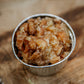 Scalloped apples in a single serving foil container on a wooden surface. Made in the kitchen of Nystrom Orchard in Worthington Minnesota.