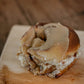 Close up of a sourdough cinnamon roll with browned butter icing on a wooden cutting board. Baked in the kitchen of Nystrom Orchard in Worthington Minnesota.