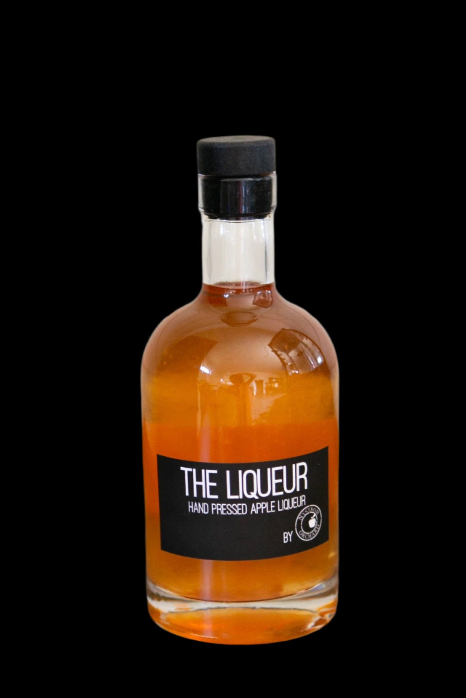 Hand pressed apple liqueur in a glass bottle on a black background. Made in the kitchen of Nystrom Orchard in Worthington Minnesota.  